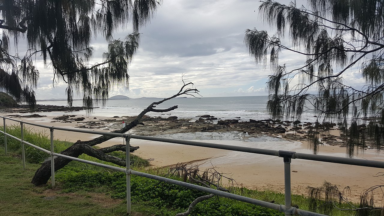 A wide Sunshine Coast beach with blue water and a quiet shoreline